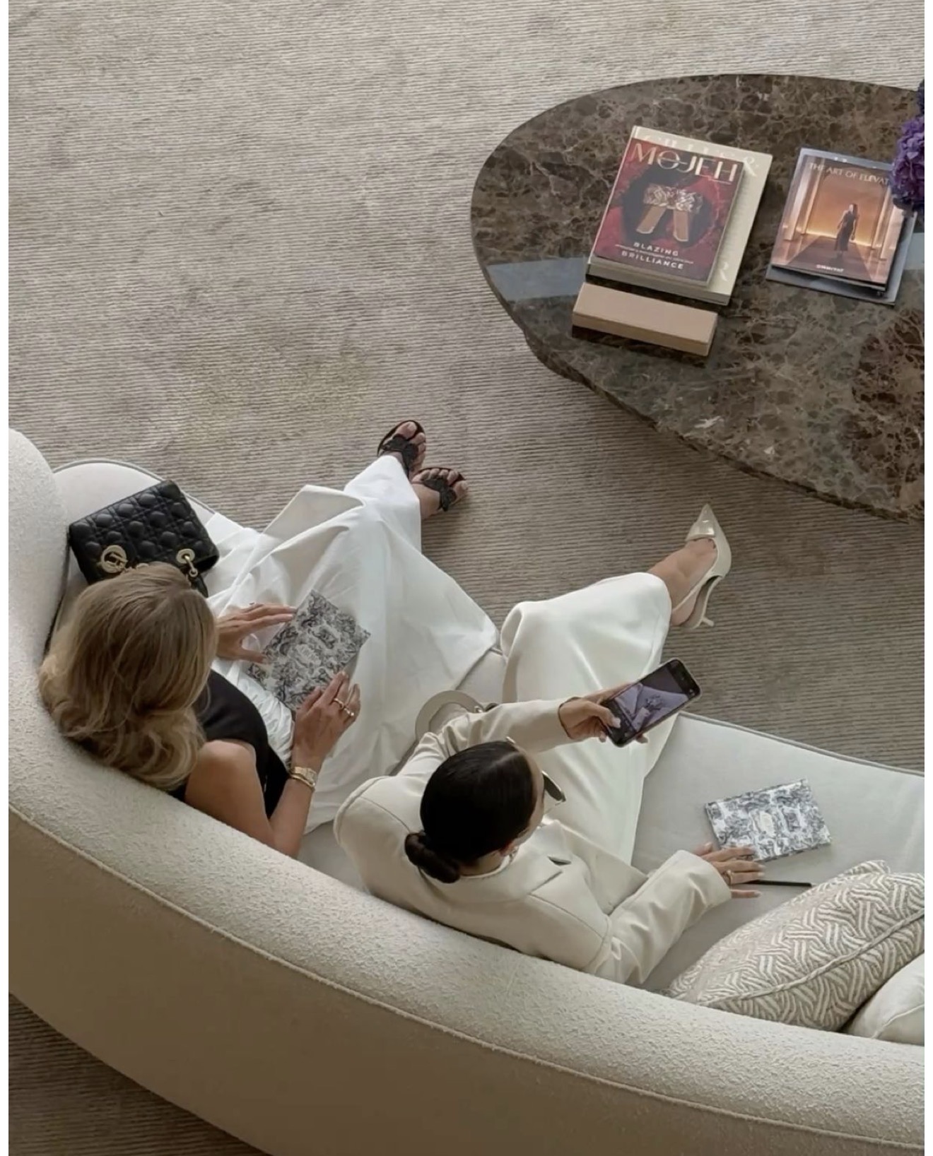 Women in neutral linen gathered in conversation at a private villa terrace